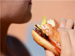 Một người đang ăn hamburger